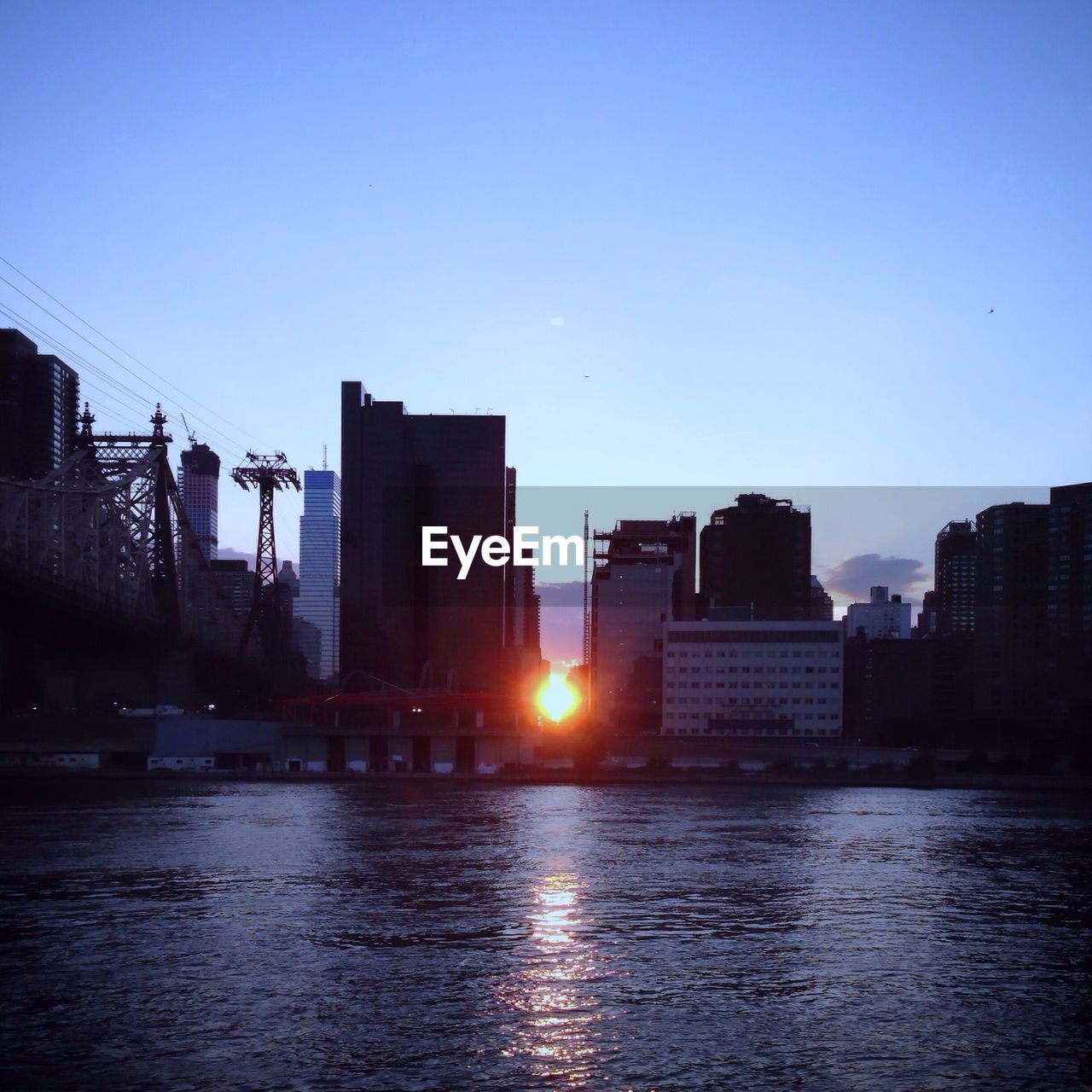 River with sunset and cityscape in background