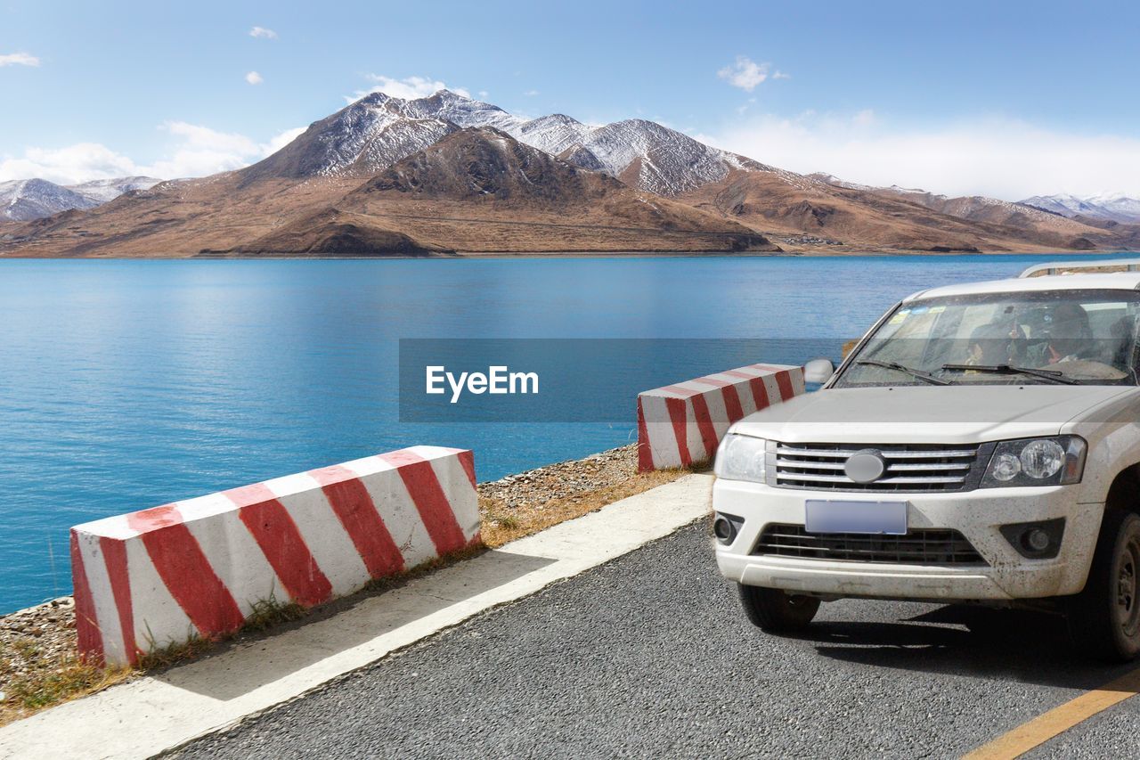 Scenic view of lake by mountains against sky