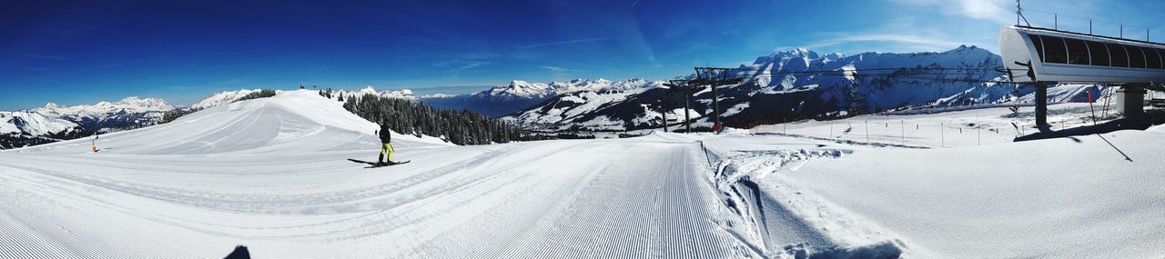 Panoramic view of snow covered mountains against sky