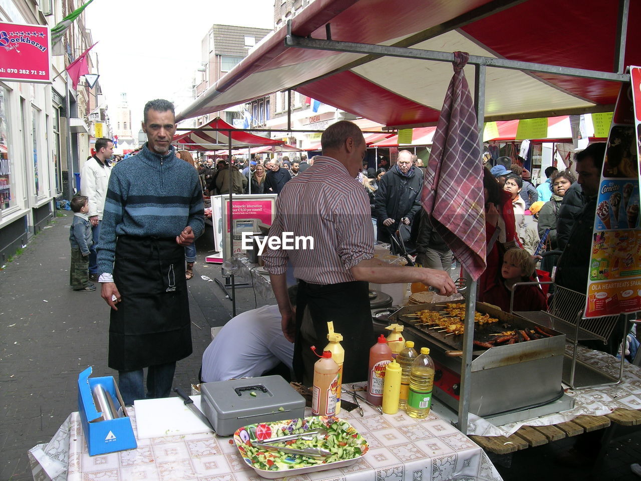 GROUP OF PEOPLE AT MARKET STALL