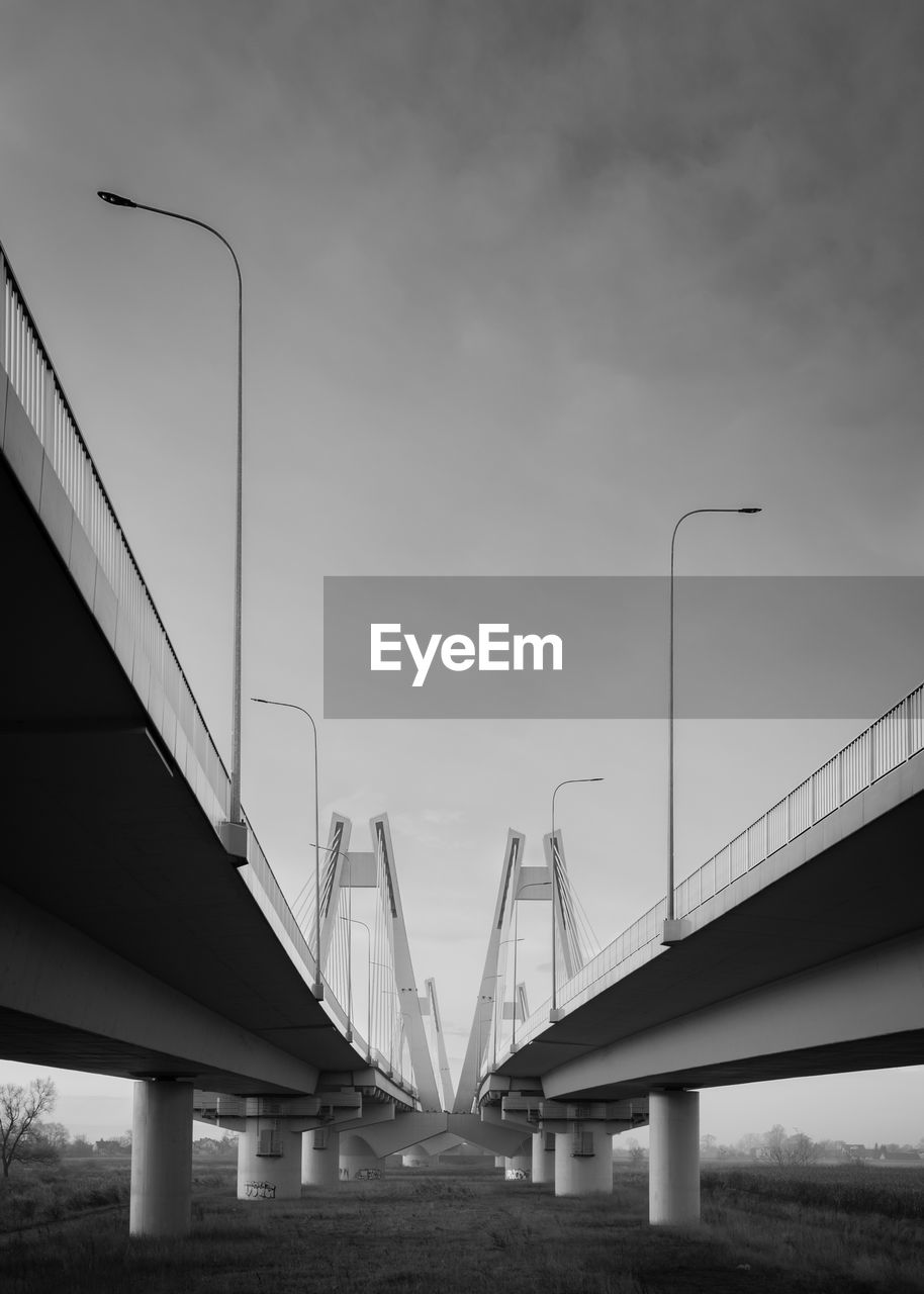 LOW ANGLE VIEW OF BRIDGE AGAINST CLOUDY SKY