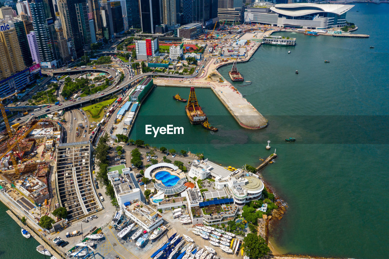 Aerial view of city by sea against sky