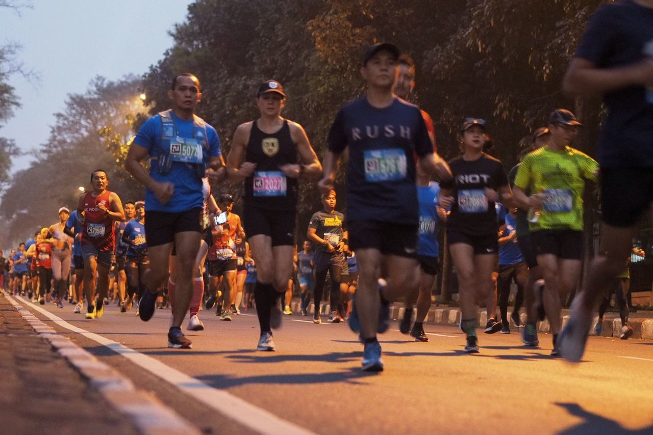 GROUP OF PEOPLE RUNNING ON STREET