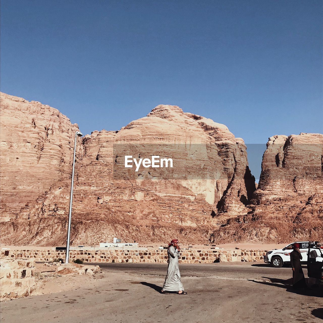 WOMAN WITH ROCKS AGAINST CLEAR SKY