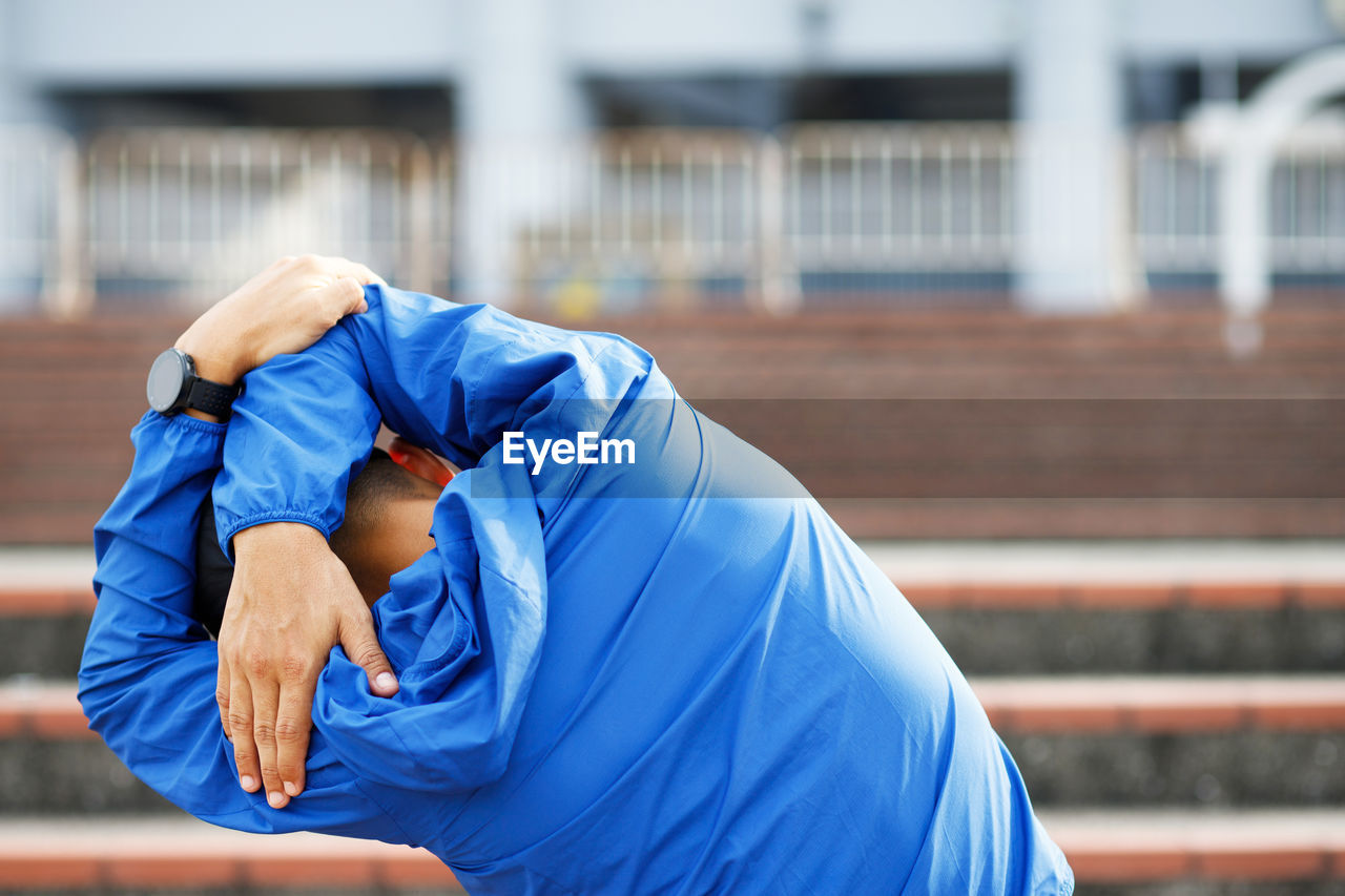 Young man runner stretching for warming up before running   