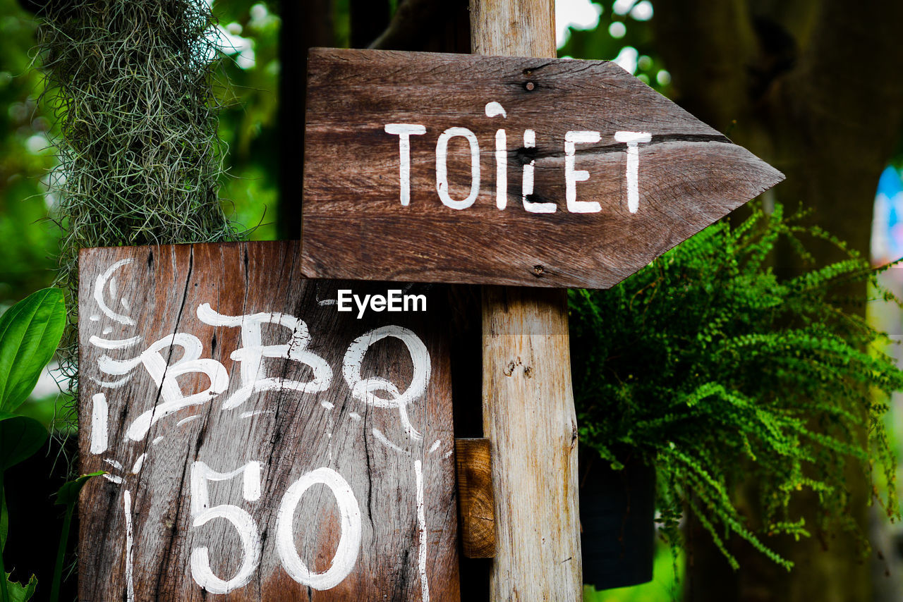 CLOSE-UP OF INFORMATION SIGN ON TREE