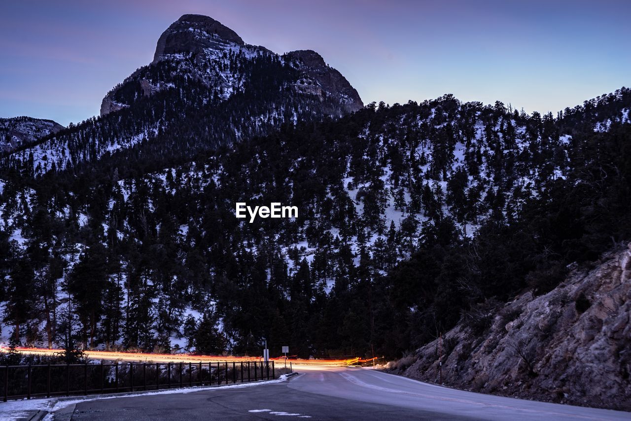 Long exposure of vehicles on road by snowcapped mountains