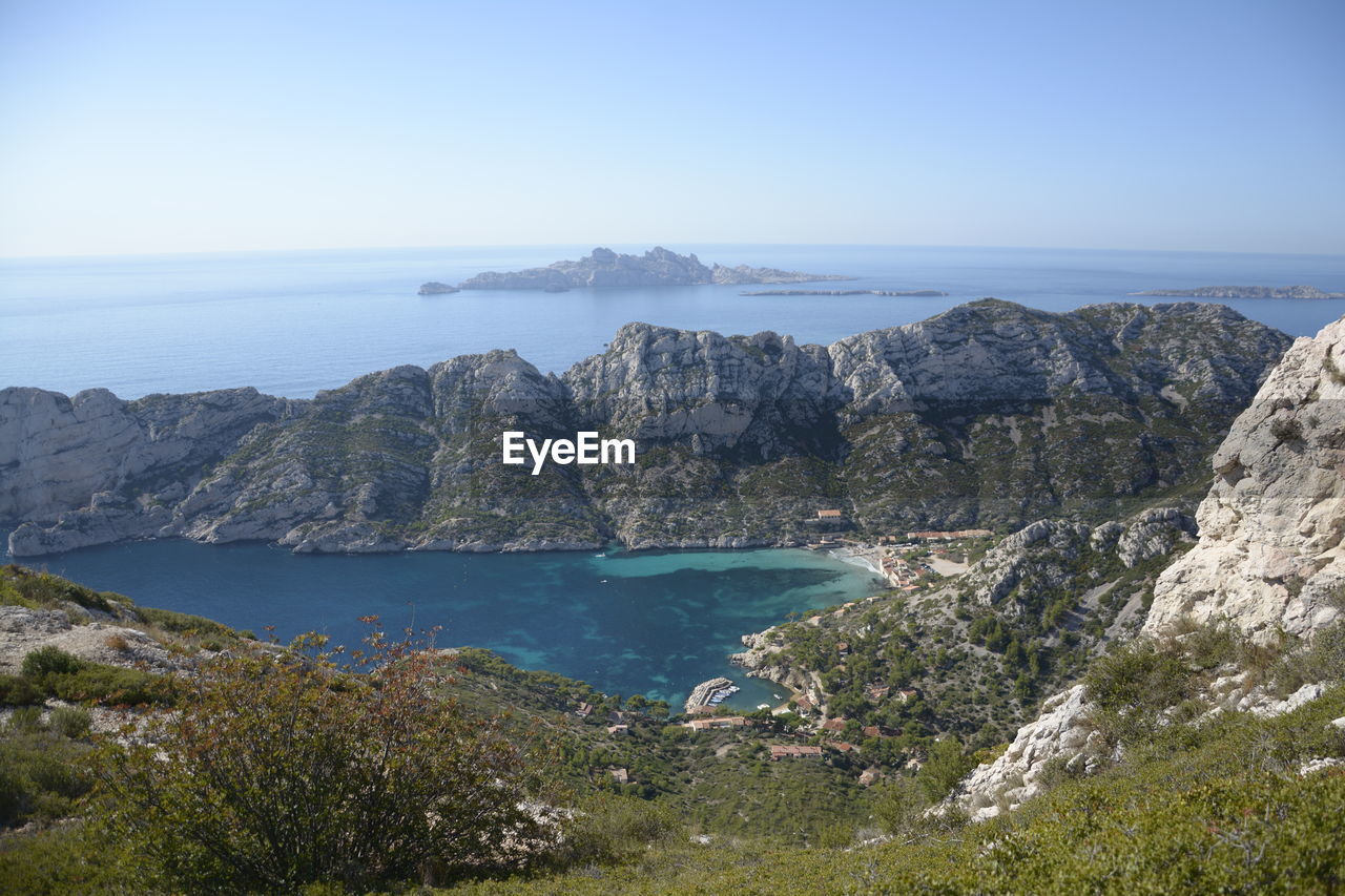 Scenic view of rock mountains in sea against sky