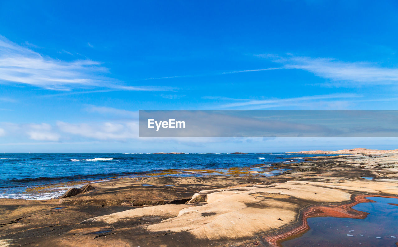 Scenic view of beach against blue sky