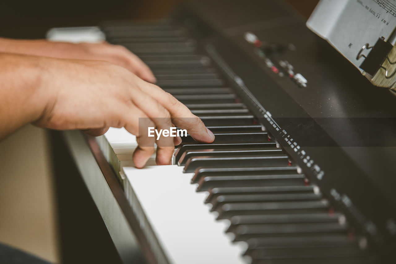 Cropped hand of person playing piano