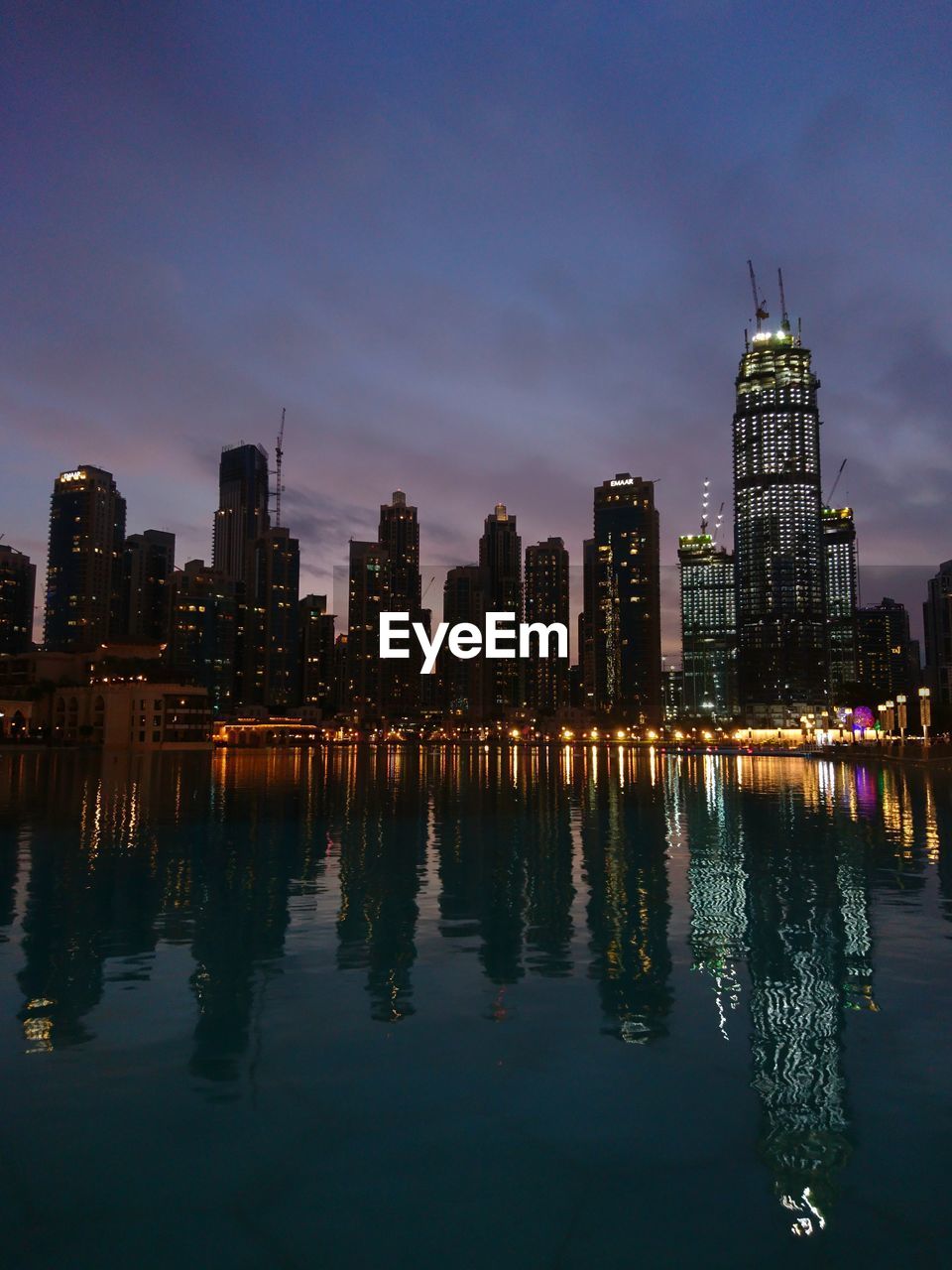 Illuminated buildings against sky at night