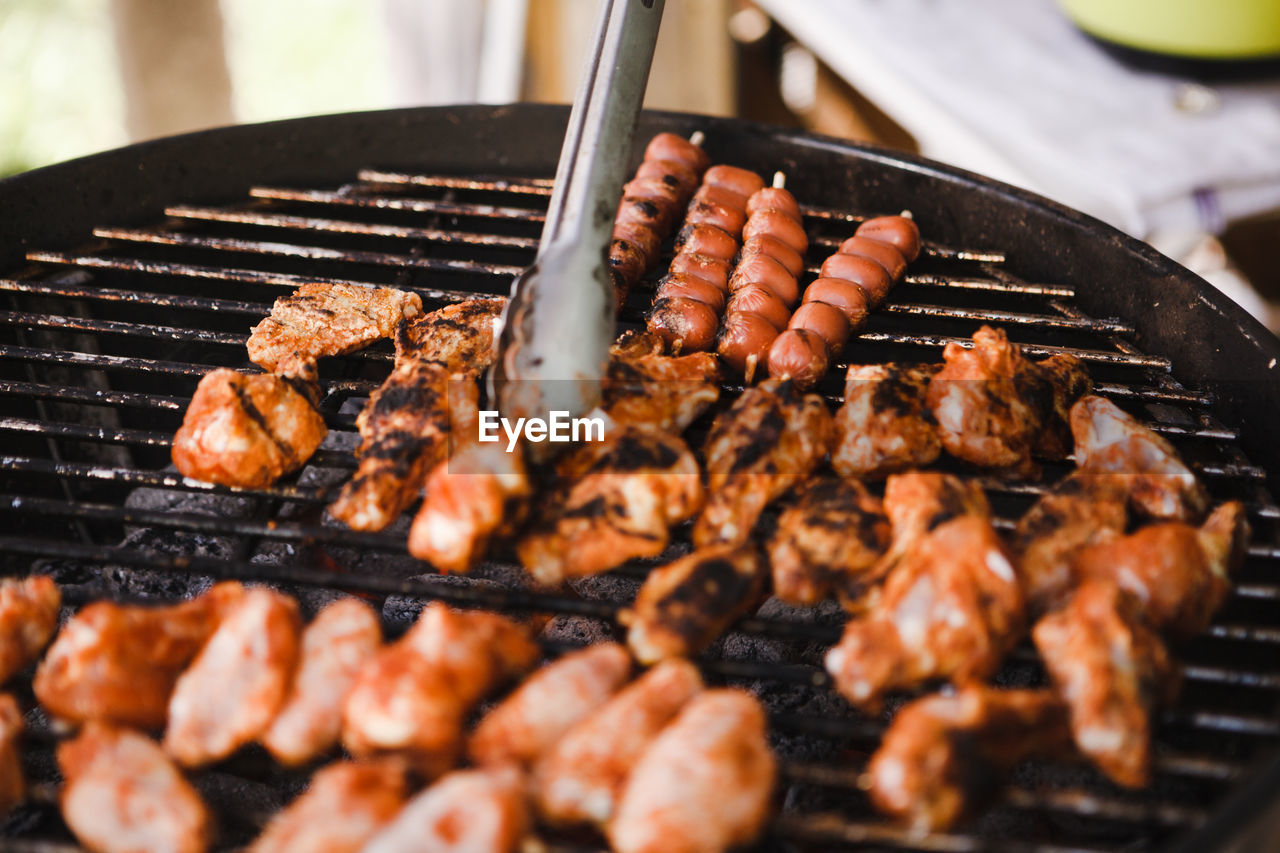 CLOSE-UP OF MEAT COOKING ON BARBECUE