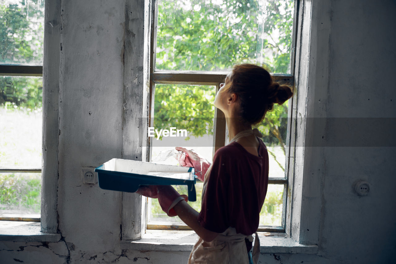 SIDE VIEW OF WOMAN HOLDING BOOK