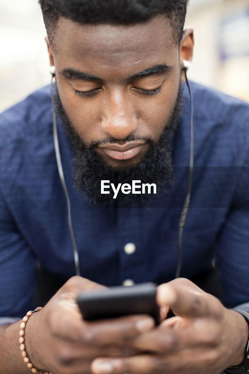 Man listening to music from mobile phone in city