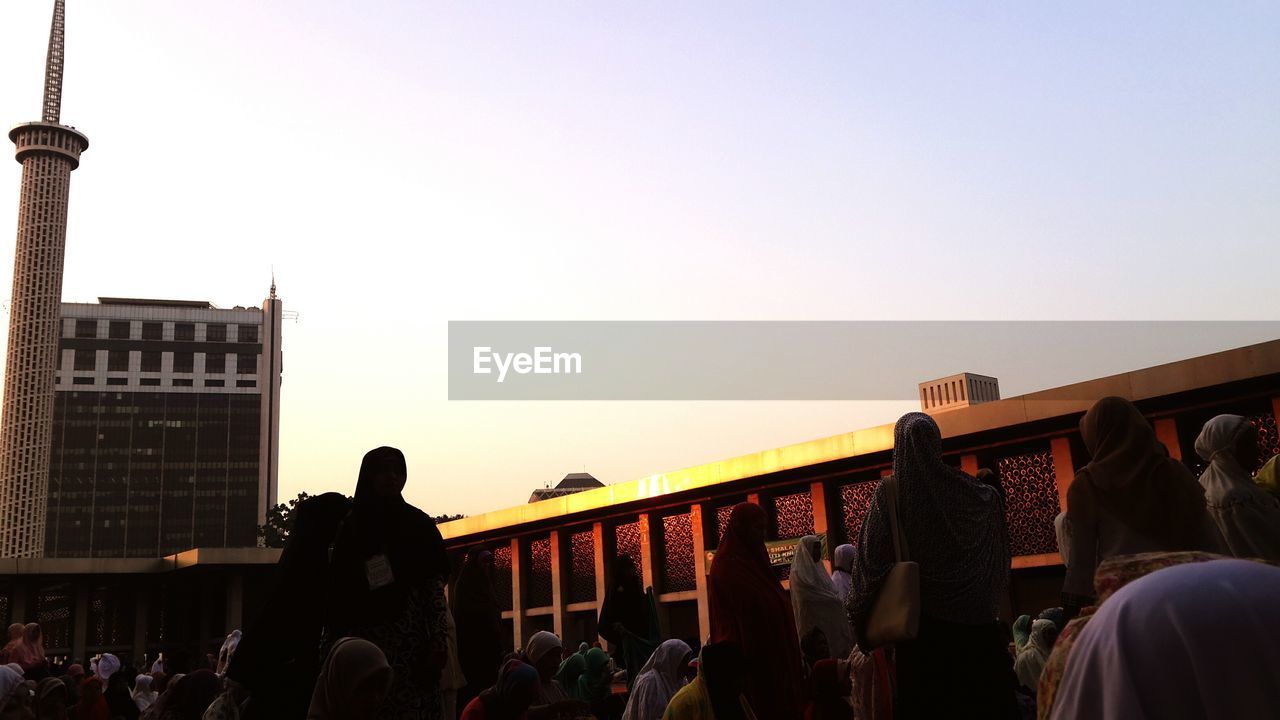 PEOPLE IN AMUSEMENT PARK AGAINST CLEAR SKY