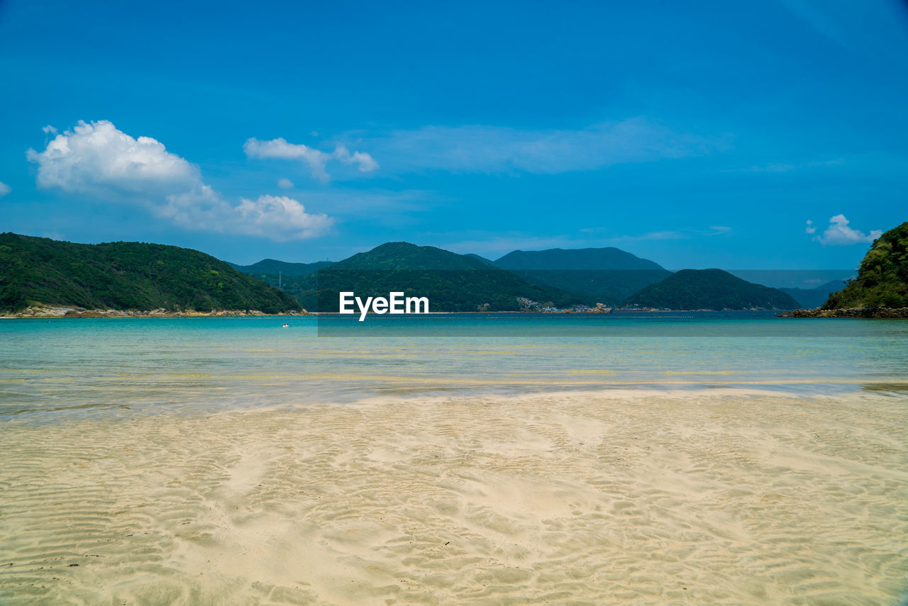 Scenic view of beach against blue sky