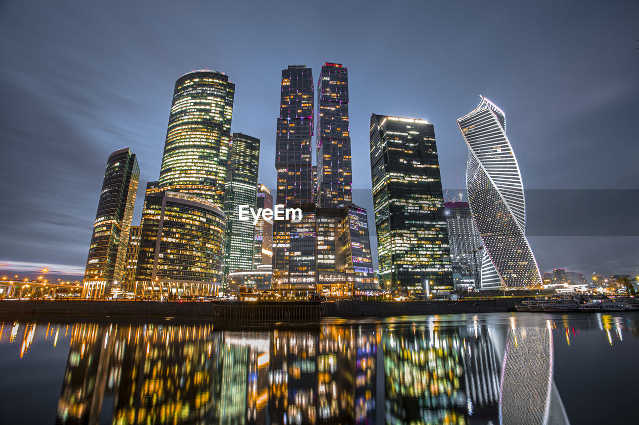 Illuminated buildings against sky at night