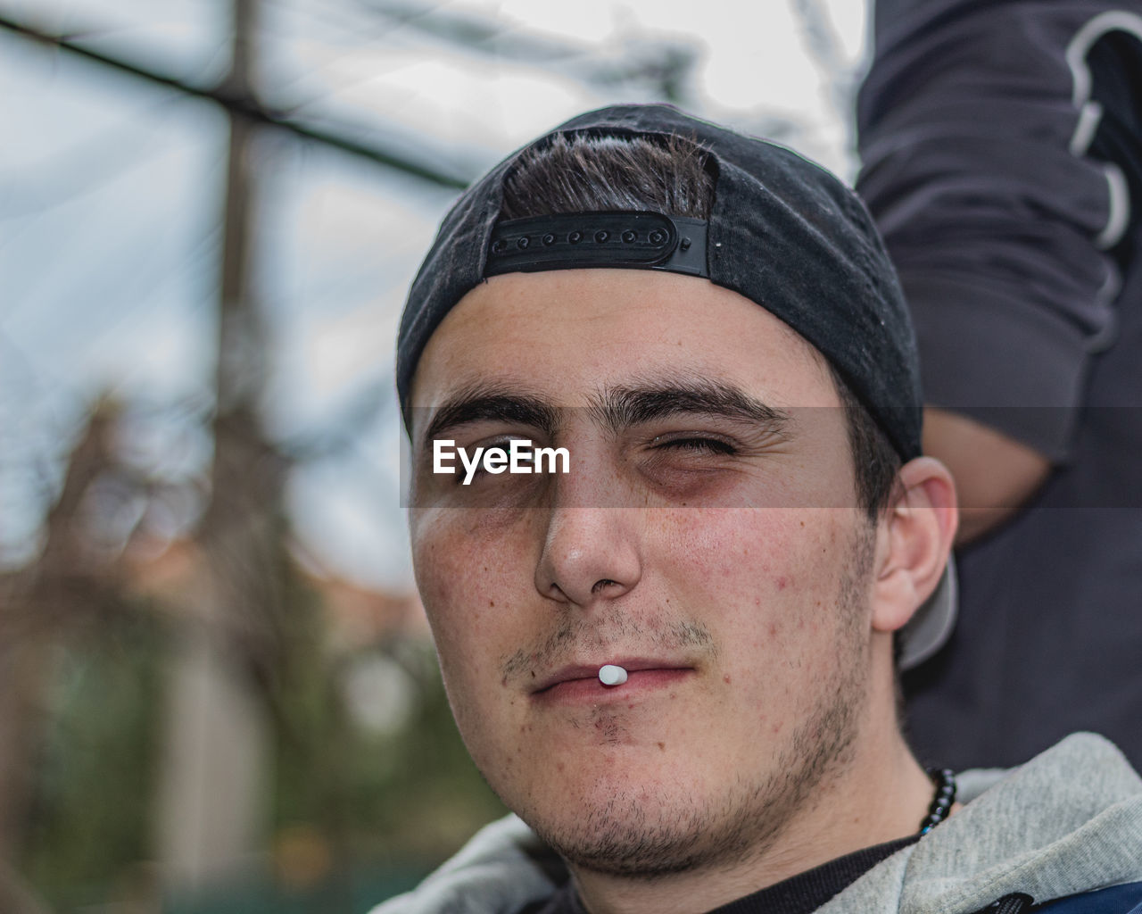 CLOSE-UP PORTRAIT OF YOUNG MAN WEARING SUNGLASSES