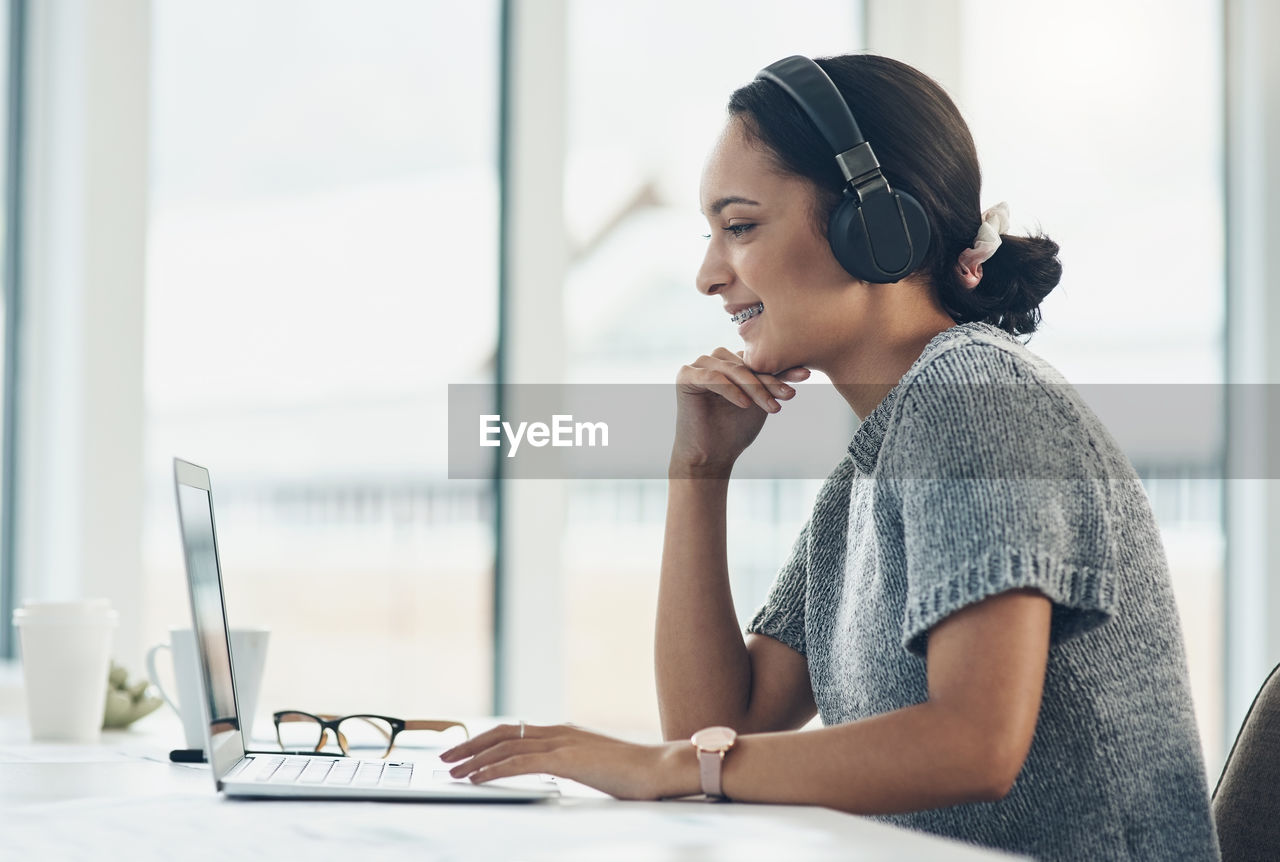 Businesswoman with braces on video call though laptop in office