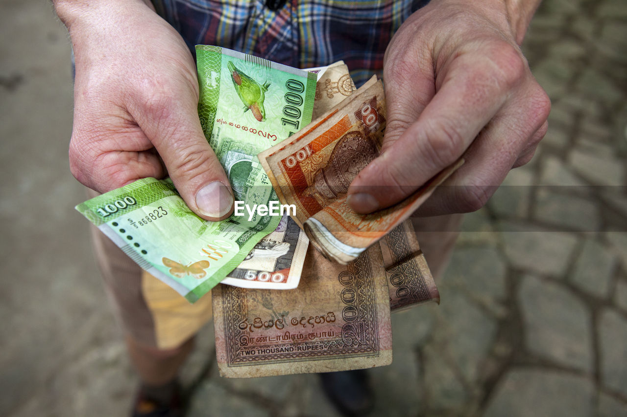 Close-up of man holding paper currency