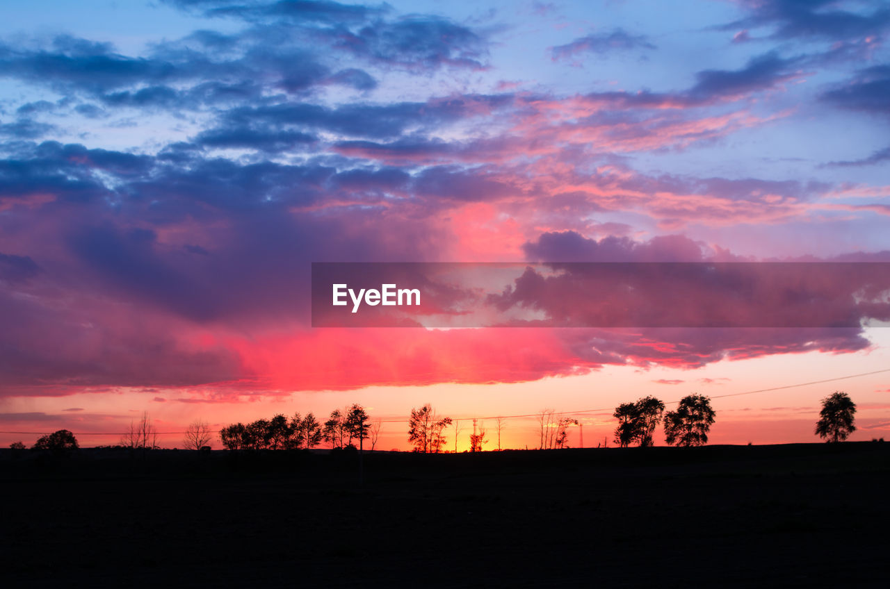 SILHOUETTE OF LANDSCAPE AGAINST DRAMATIC SKY