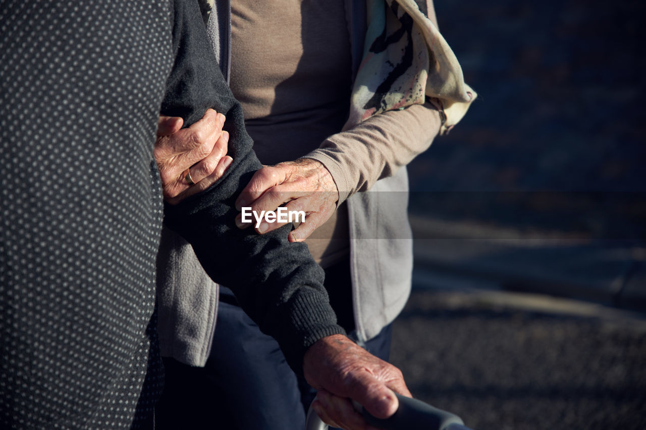 Midsection of couple holding hands