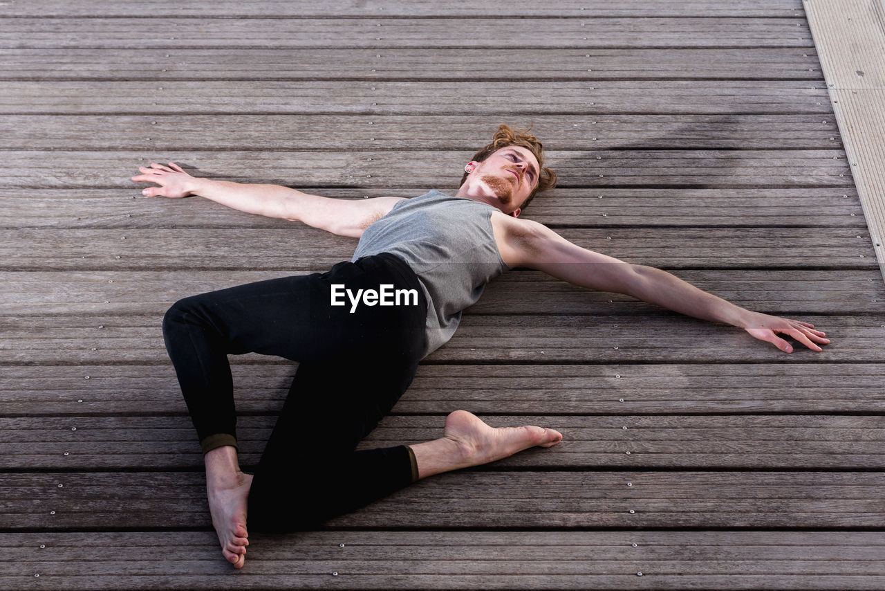 Full length of man lying on wooden floor