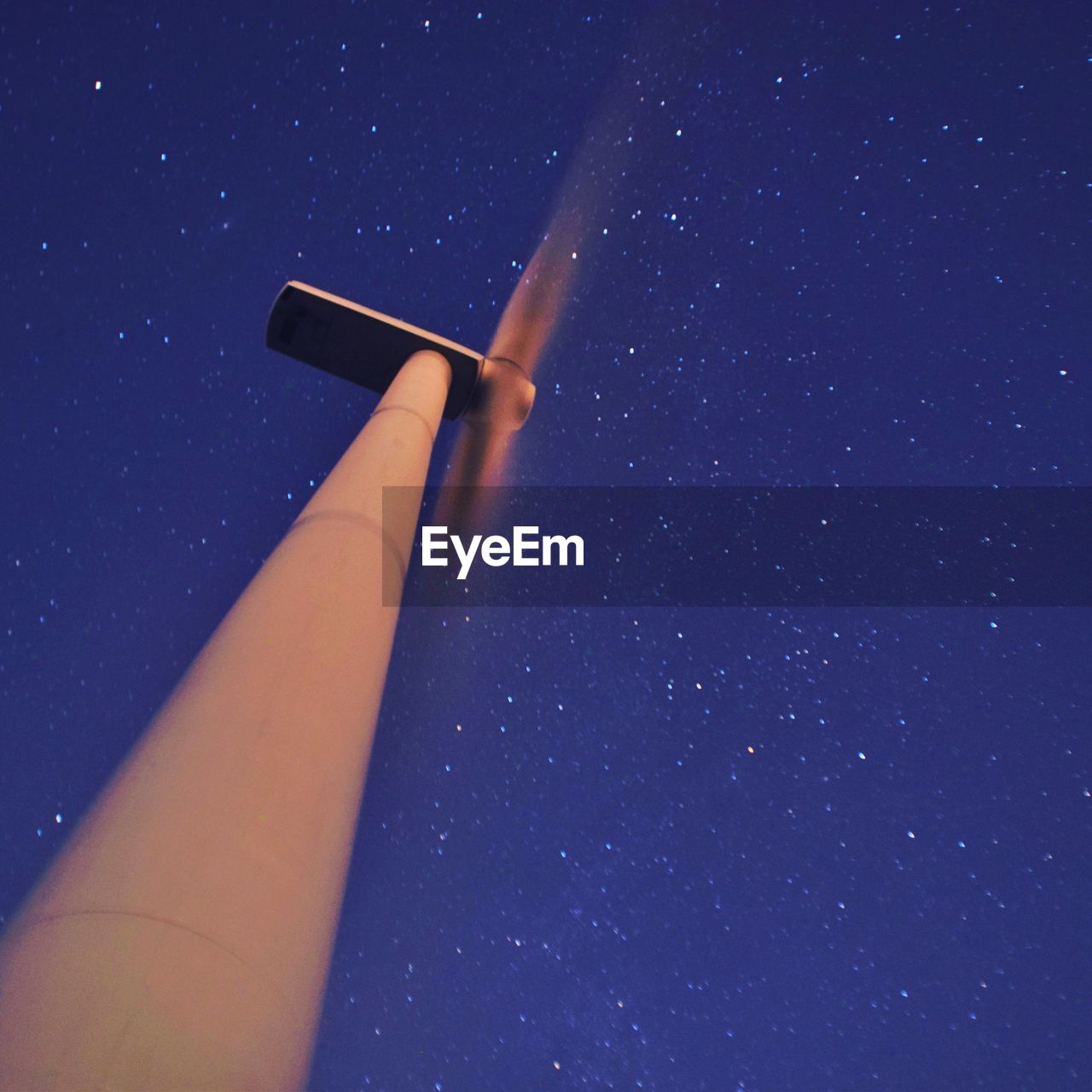 Low angle view of windmill against star field