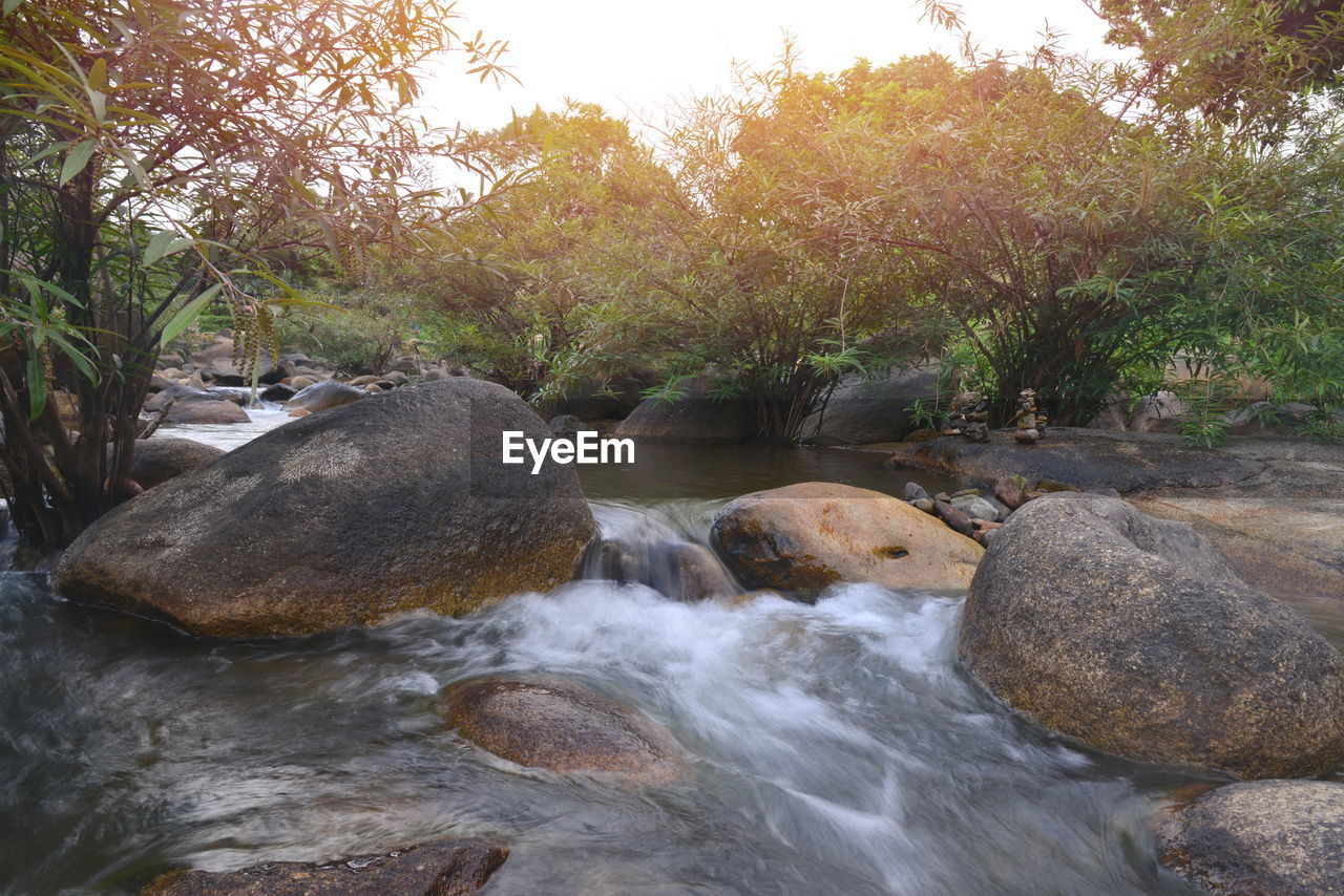 STREAM FLOWING THROUGH ROCKS IN RIVER