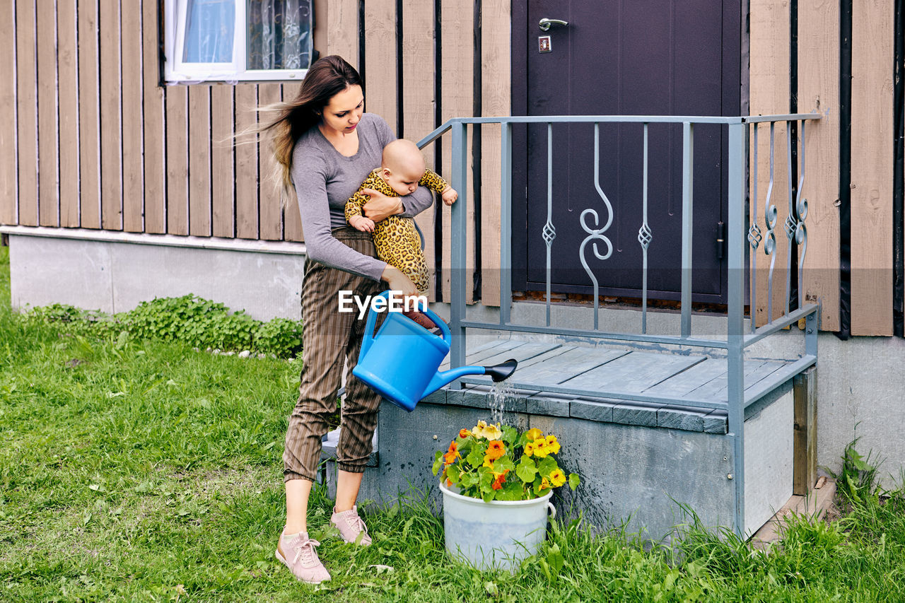 side view of young man standing on field in yard