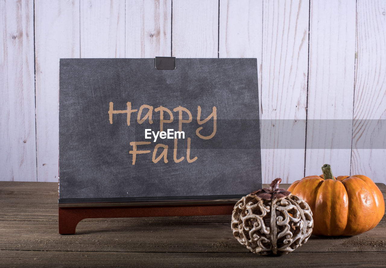 Pumpkins and blackboard on table