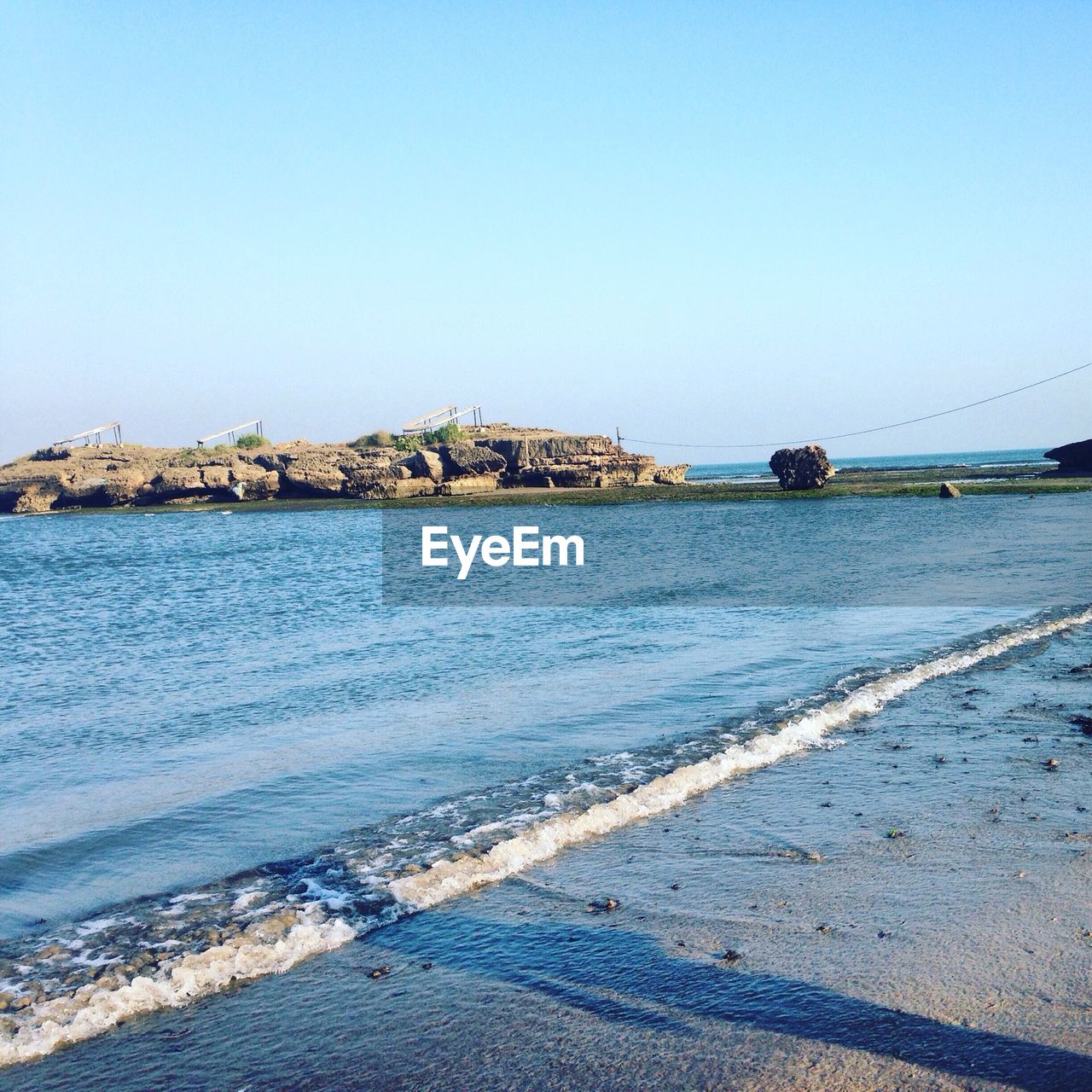 Shadow on sea shore against clear sky