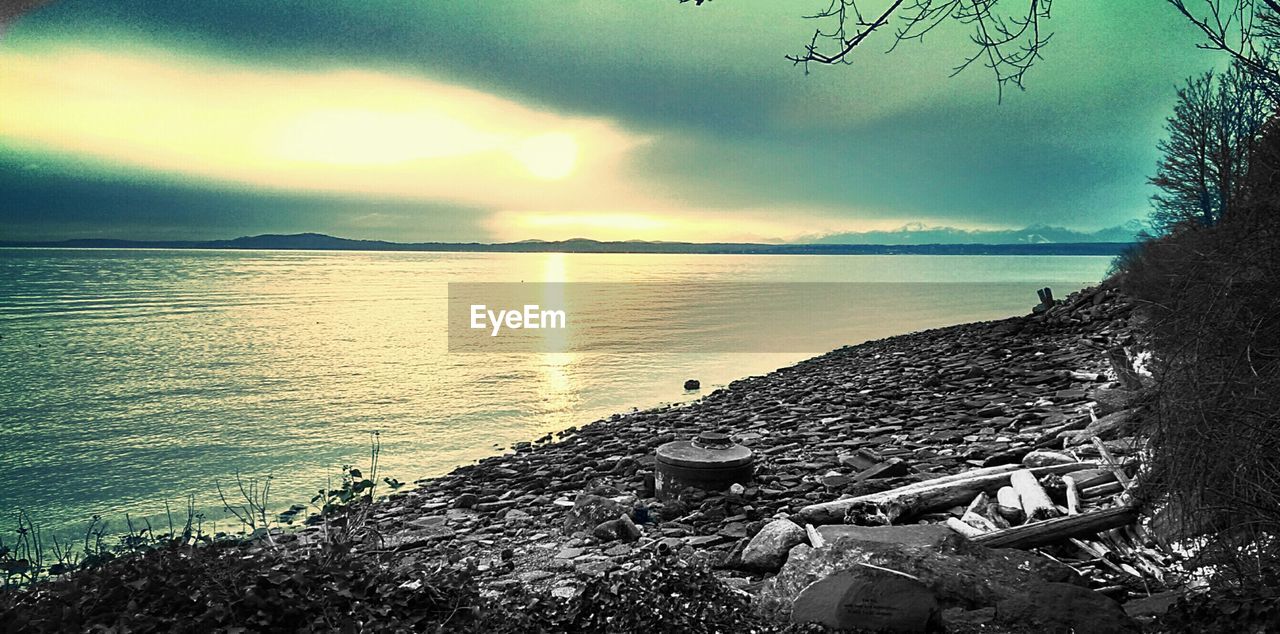 Scenic view of river against sky at sunset