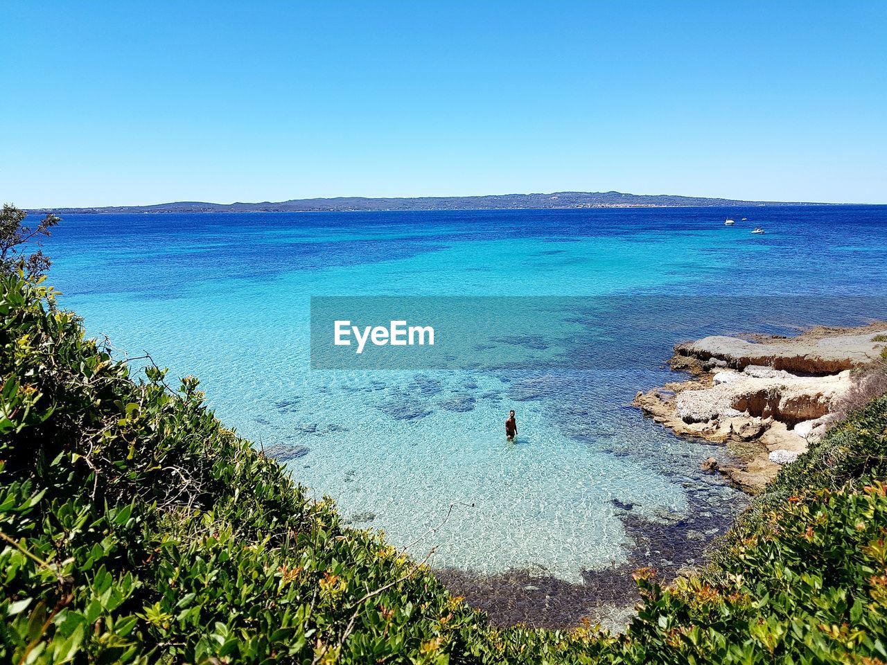 High angle view man in sea against clear blue sky