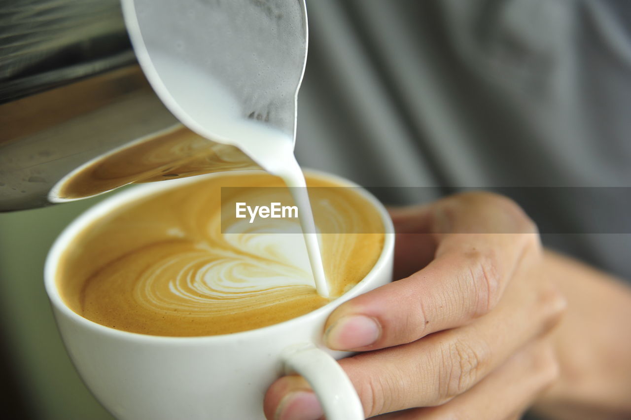 CROPPED IMAGE OF HAND POURING COFFEE