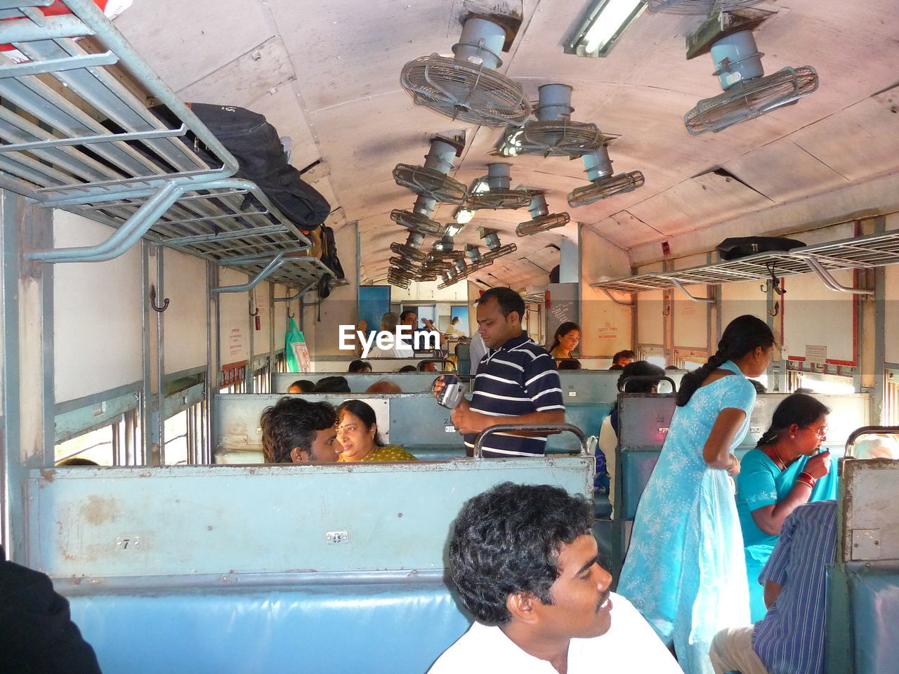 GROUP OF PEOPLE SITTING IN BUS AT STATION