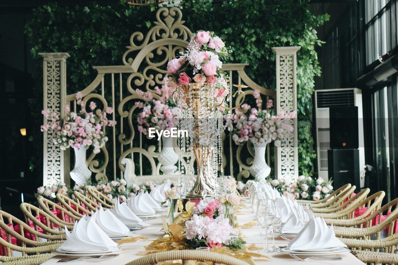 Vases on dining table amidst chairs