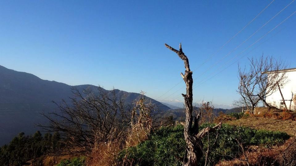 Scenic view of mountains against clear blue sky