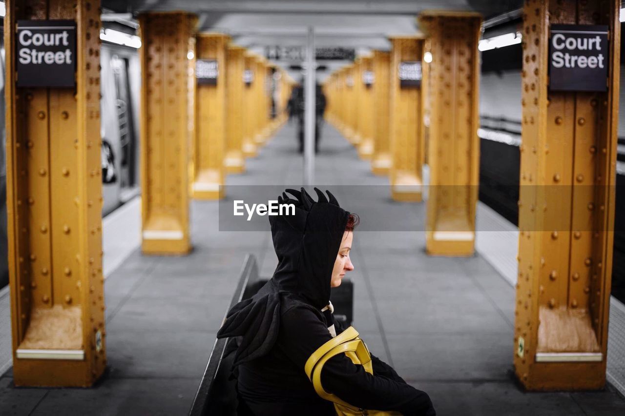 Young woman in costume waiting at subway station