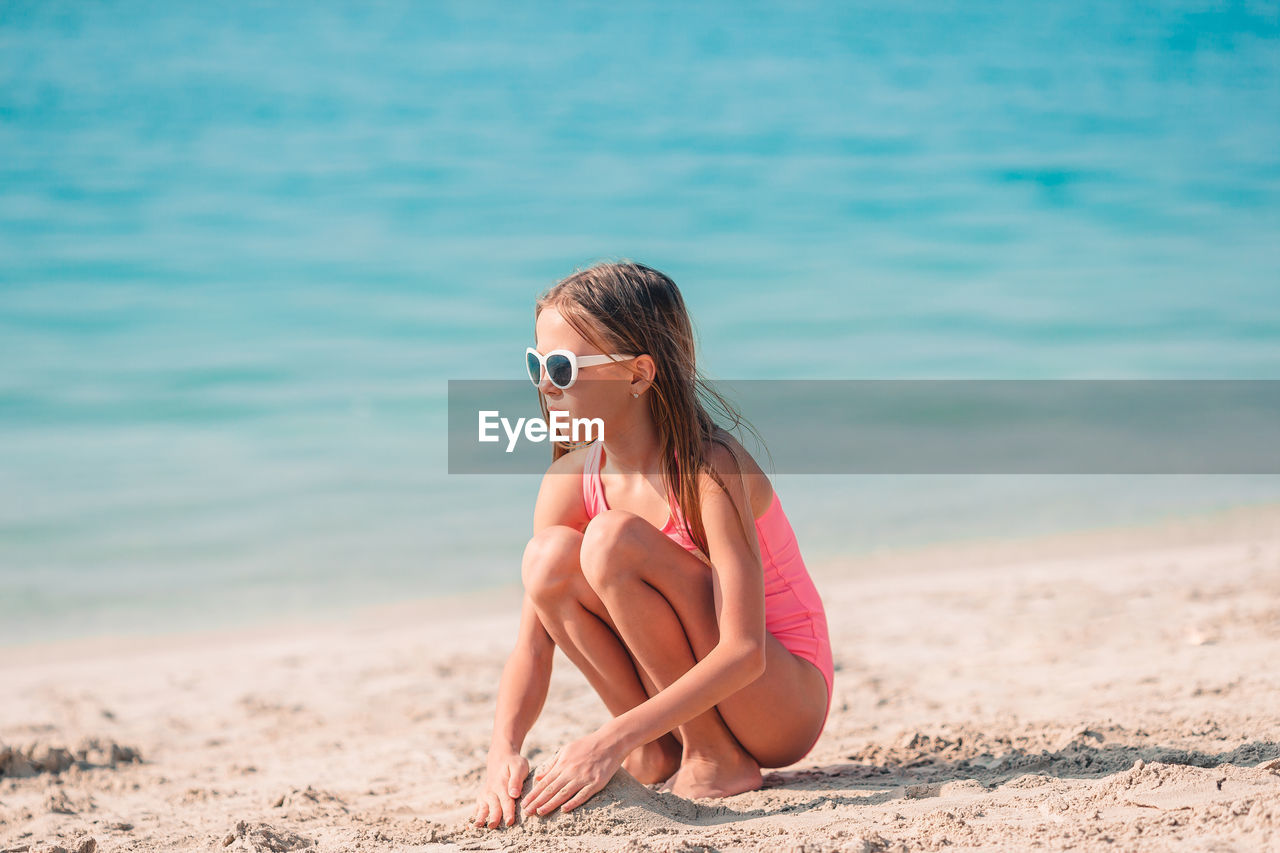 Woman wearing sunglasses sitting on beach