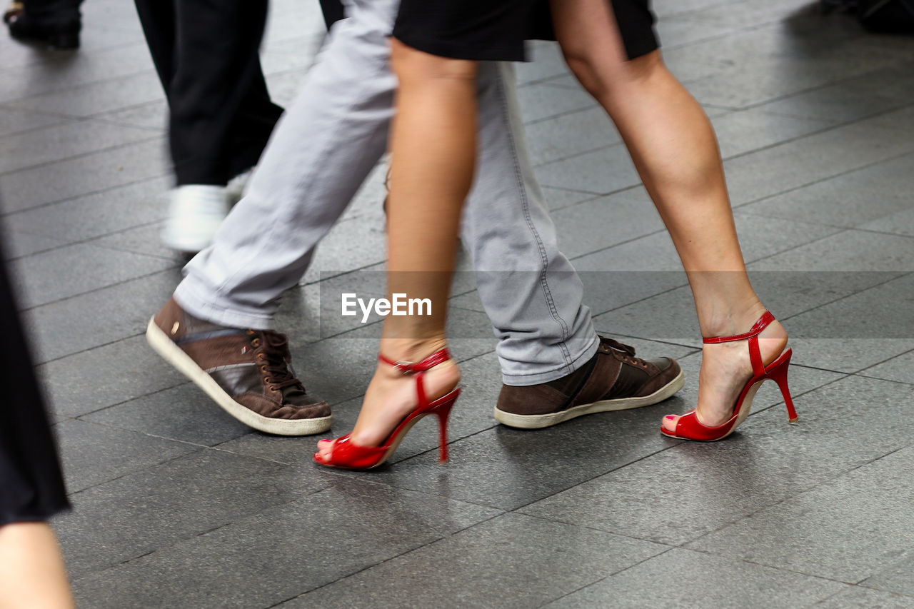 Low section of people walking on footpath in city