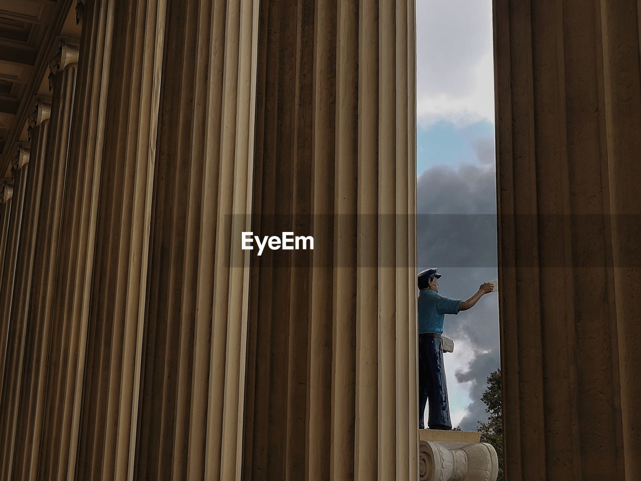 LOW ANGLE VIEW OF MAN STANDING ON WOODEN STRUCTURE