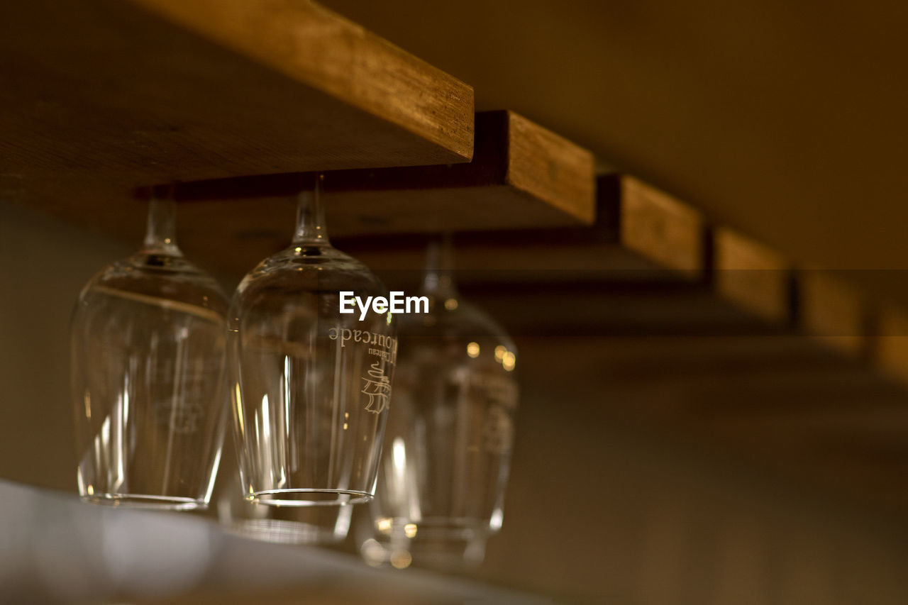 CLOSE-UP OF EMPTY GLASS BOTTLE ON TABLE