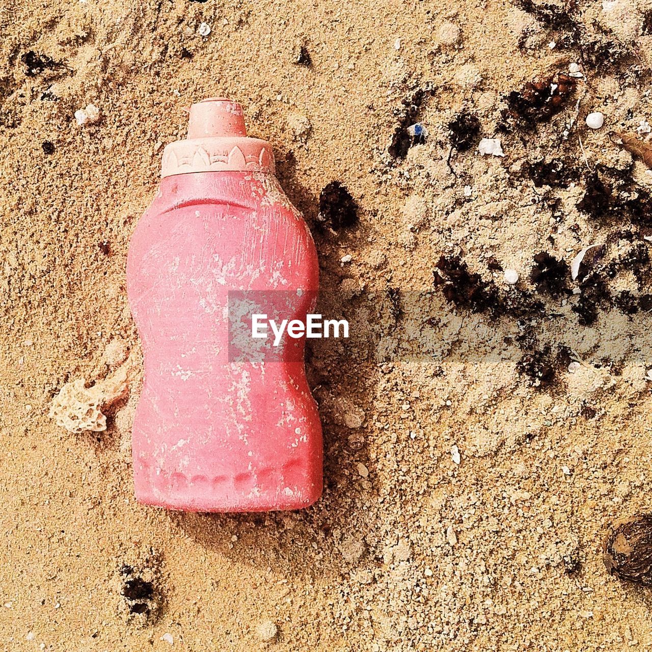 HIGH ANGLE VIEW OF PINK WET SAND ON SHORE