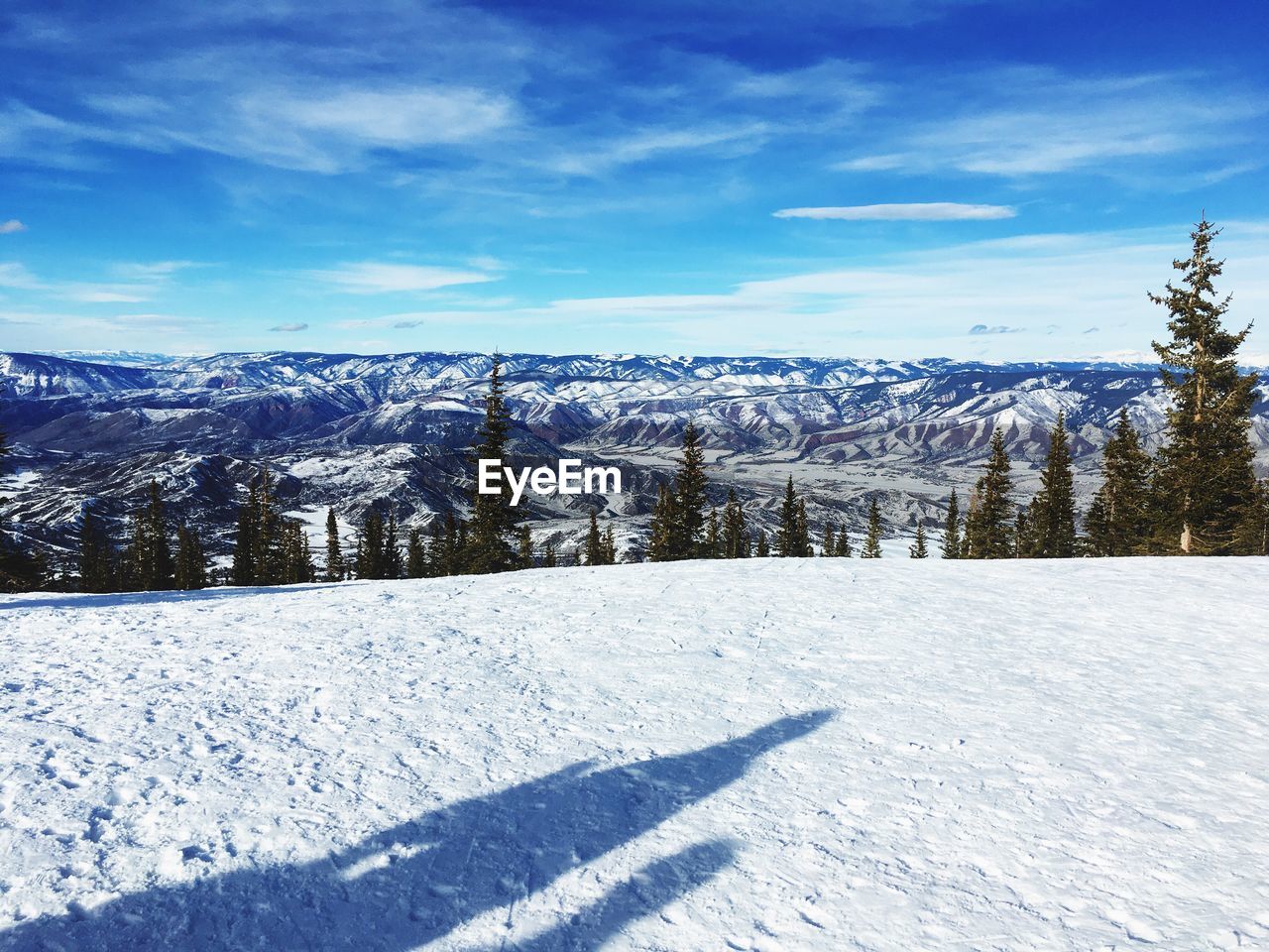 Snow covered landscape against blue sky