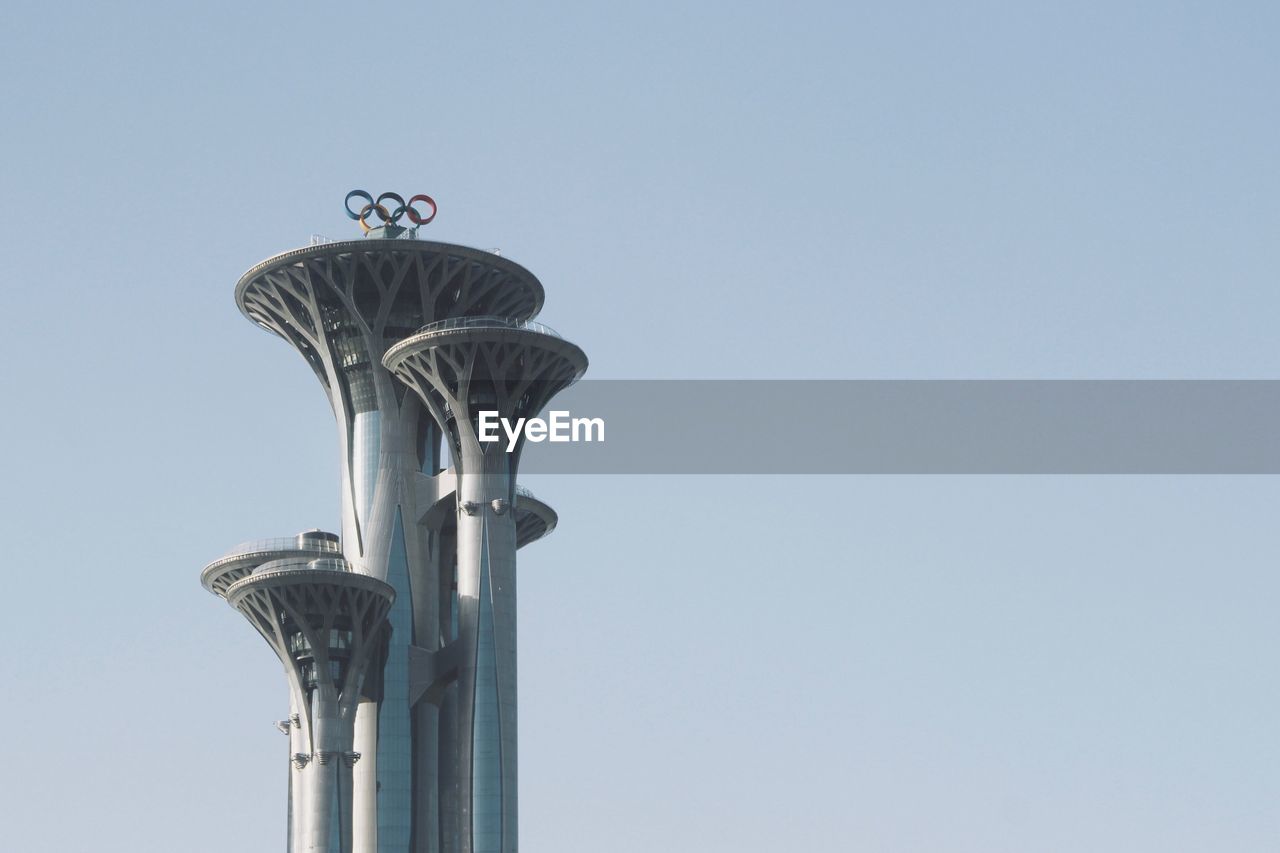 LOW ANGLE VIEW OF BIRD PERCHING ON STATUE AGAINST SKY