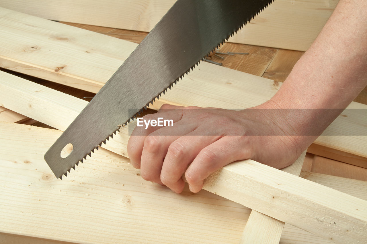 CLOSE-UP OF MAN WORKING ON HARDWOOD FLOOR AT HOME