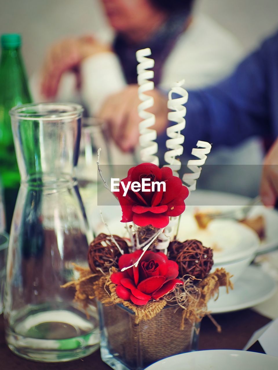 food and drink, table, food, flower, bottle, indoors, vase, adult, container, freshness, plant, drink, flowering plant, men, nature, focus on foreground, selective focus, meal, refreshment, celebration, glass, tableware, red, lifestyles, close-up, business