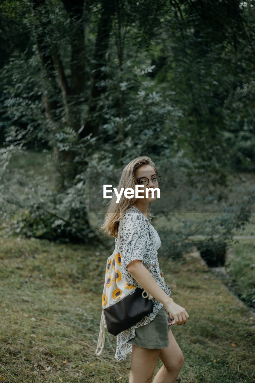 Full length of woman standing in forest