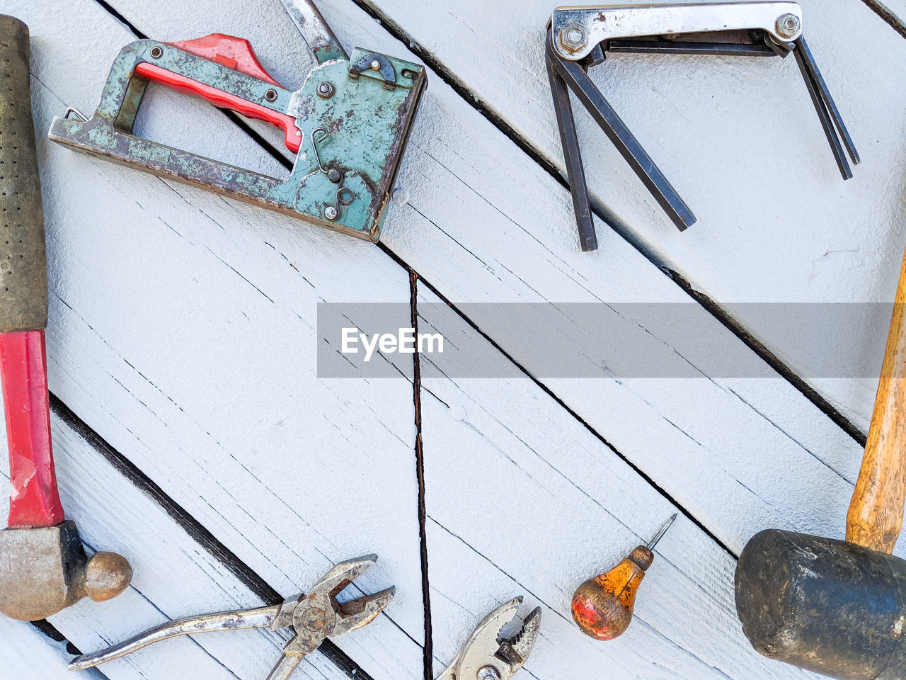 Flat lay of old tools against a rustic painted wooden background